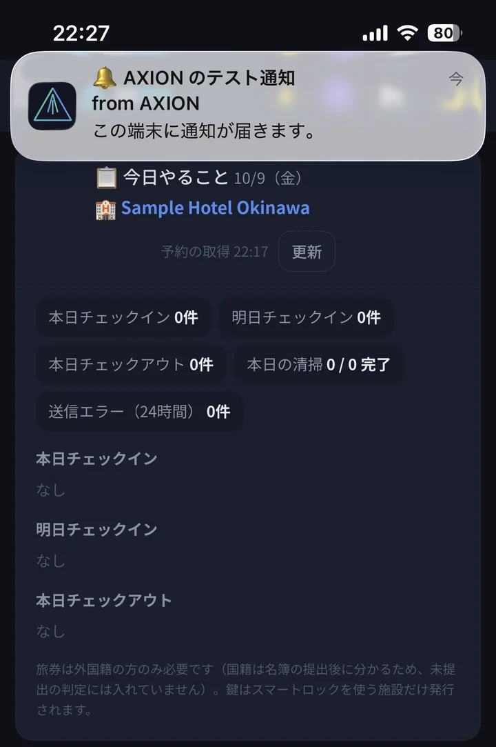 iPhoneのロック解除中の画面上部に、AXIONのアイコン付きでテスト通知「この端末に通知が届きます。」が表示されている。背後にはAXIONの「今日やること」の画面が開いている